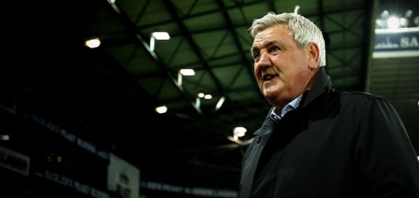 Steve Bruce surveys the crowd while standing on a football pitch